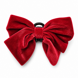 A red velvet bow hair clip on a solid white background.