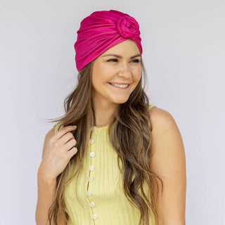 Woman wearing a bright pink turban with a white background